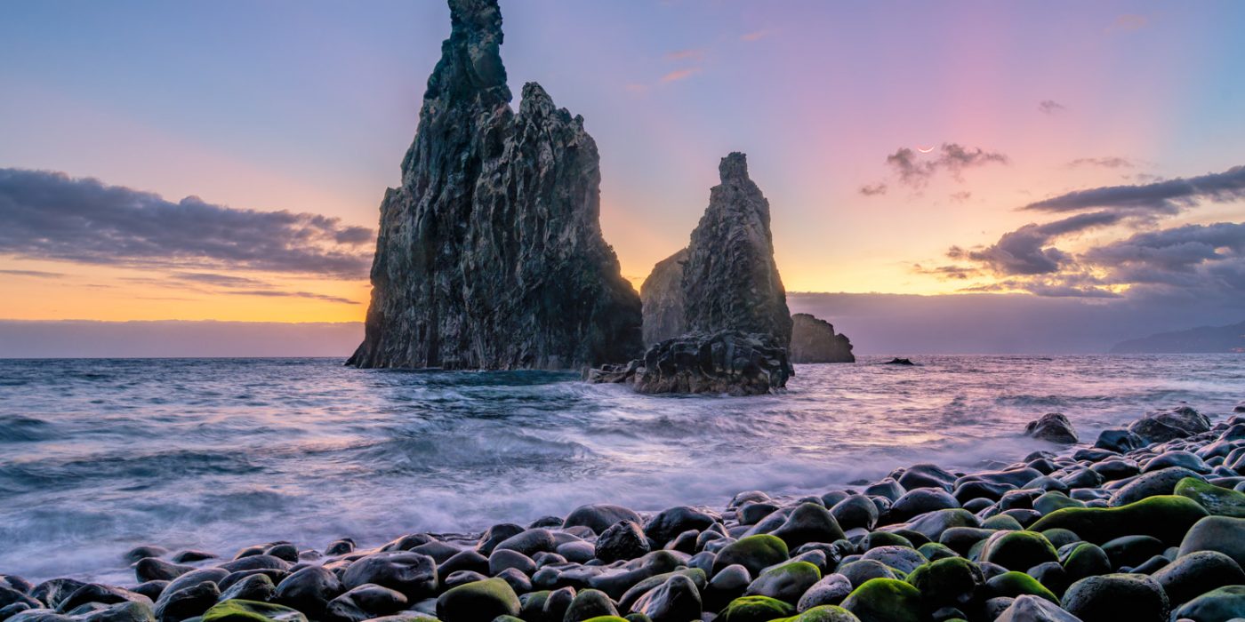 Ilheus da Janela at Sunrise View of the Ilheus da Janela at sunrise with a crescent moon in the sky.