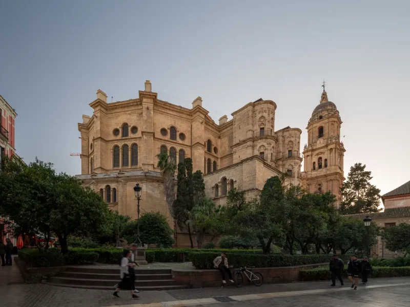 Malaga Cathedral Exterior-5 Historic cathedral surrounded by greenery.